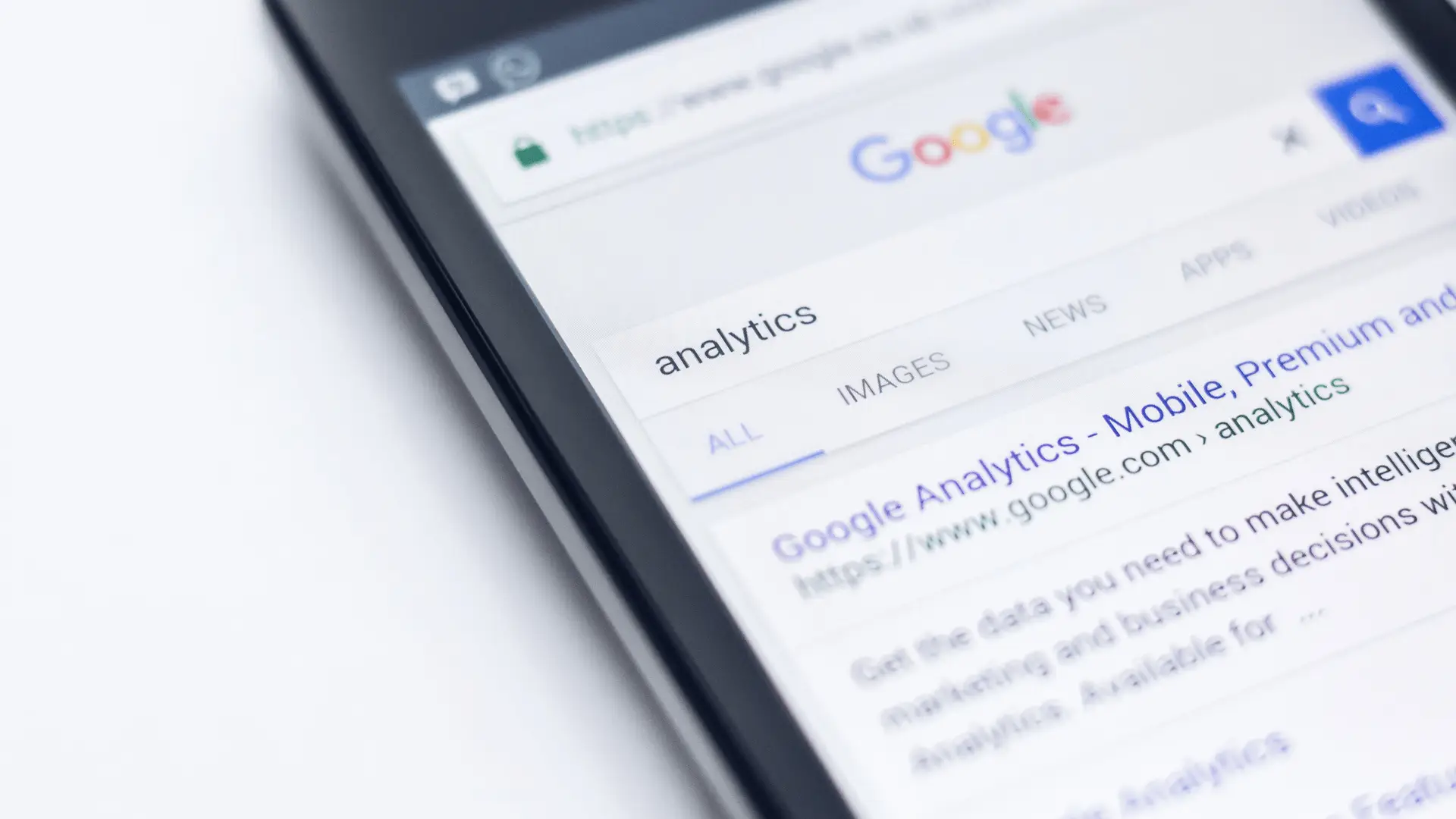 Close-up of a smartphone displaying Google search results for “analytics,” including a Google Analytics link